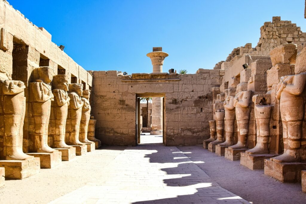 View of ancient statues along a stone corridor at Luxor Temple, Egypt.